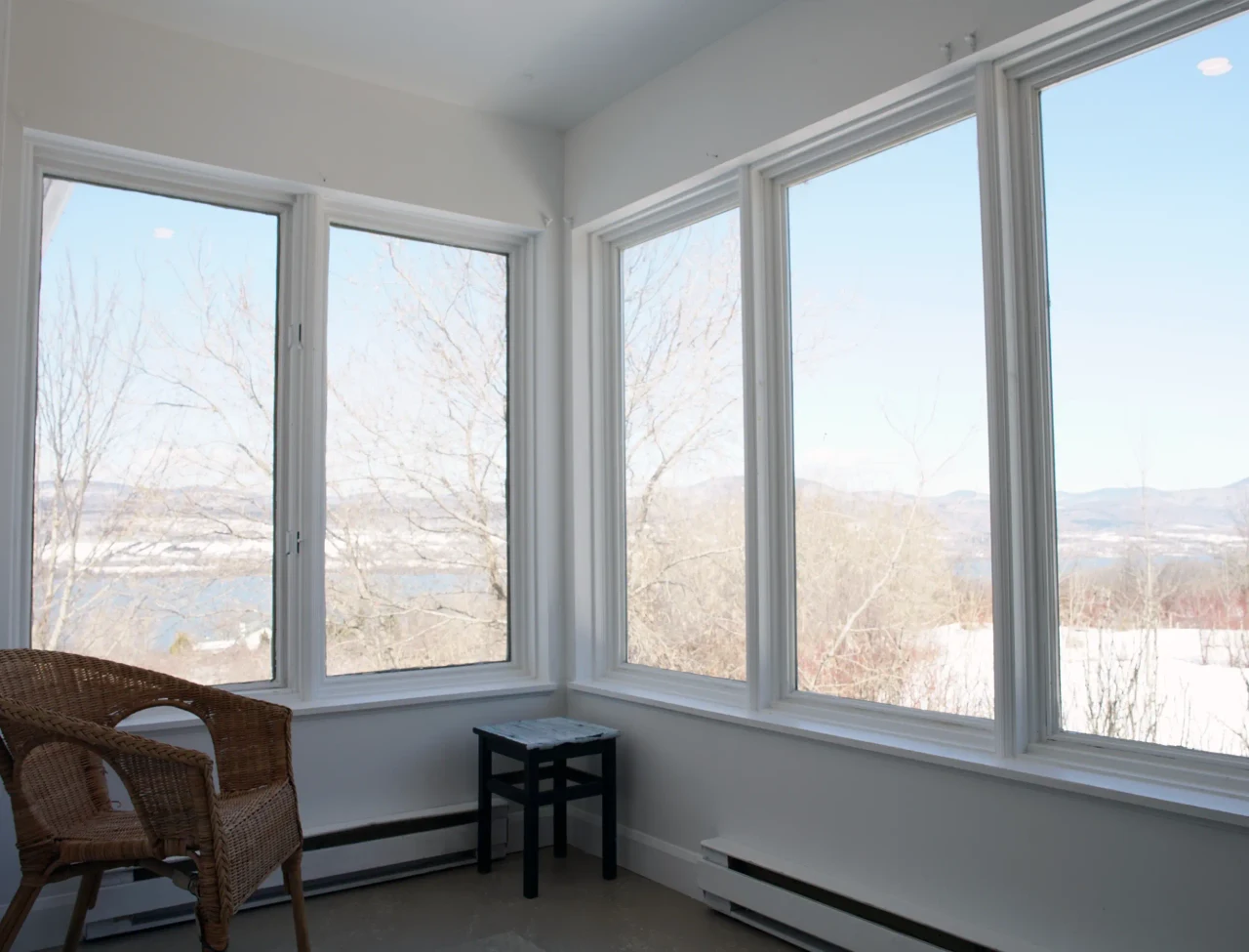 Fauteuils dans l’aire de repos vitrée de la Résidence Sainte-Famille, avec vue sur le fleuve