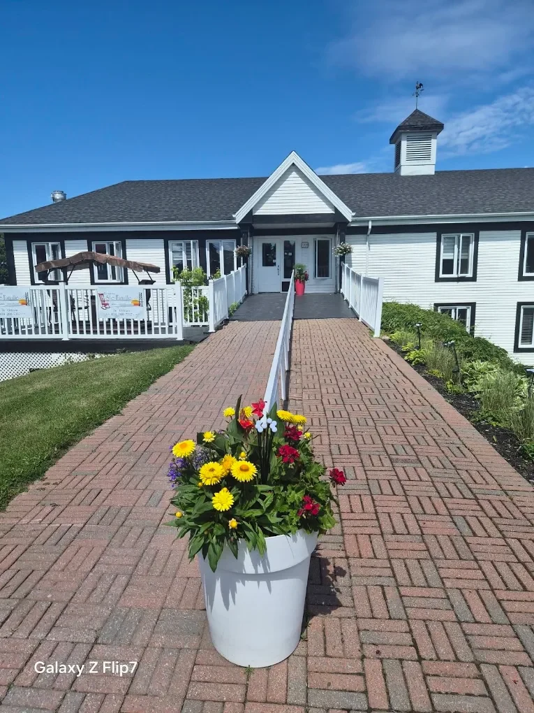 Allée pavée et pot de fleurs devant l’entrée de la résidence