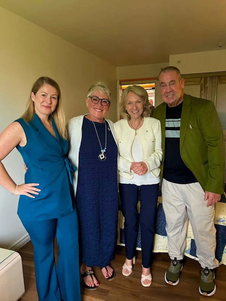 Quatre personnes réunies pour une photo à l’intérieur de la résidence