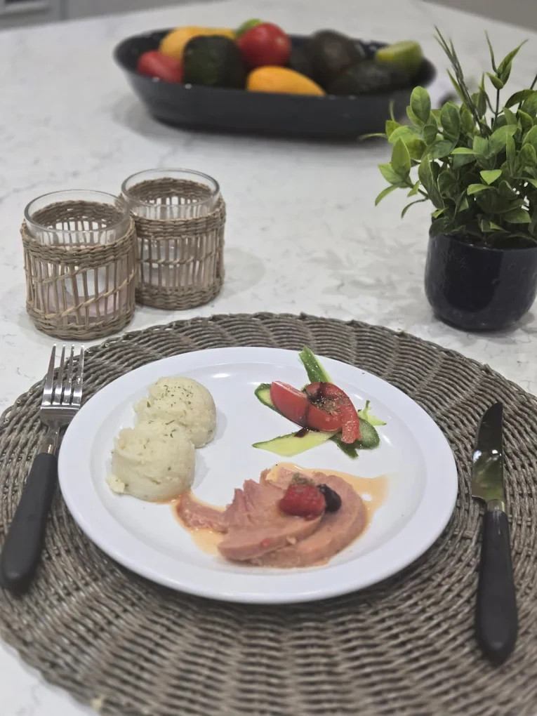 Une assiette de viande en sauce, de pommes de terre et de légumes sur une table dressée