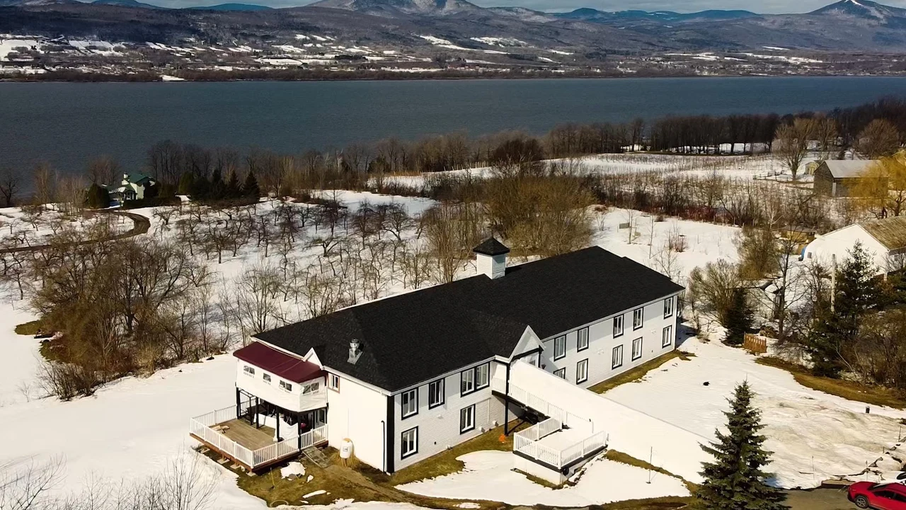 Vue aérienne hivernale de la Résidence Sainte-Famille, avec le fleuve et les collines en arrière-plan
